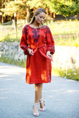 Fototapeta premium Beautiful blonde Ukrainian girl with blue eyes in folk clothing. Boho style in fashion. Traditional and nature style. National look