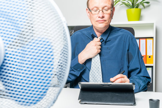 businessman is working in a hot office and is sweating