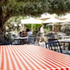 Table background with blurred restaurant in distance.