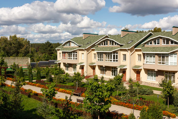 Fototapeta premium A row of new houses in a suburban village on a sunny day. Russia