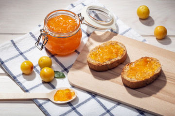 Pot of sweet jam, plum fruit and toasts