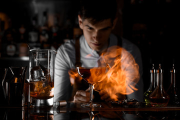 Close shot of bartender firing up a drink