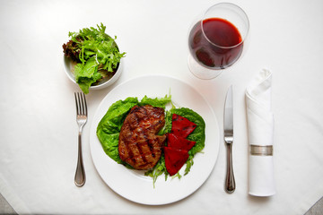 Steak on the plate with red wine.