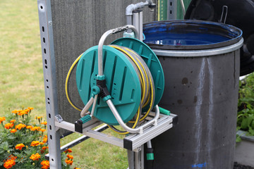 A barrel of water and a watering hose