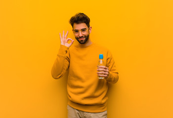 Young man cheerful and confident doing ok gesture