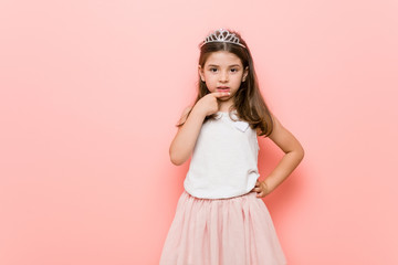 Little girl wearing a princess look biting fingernails, nervous and very anxious.