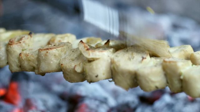 A street food vendor cooking chopped mutton seekh kebab on a coal furnace. 