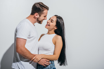 young couple hugging while smiling and looking at each other