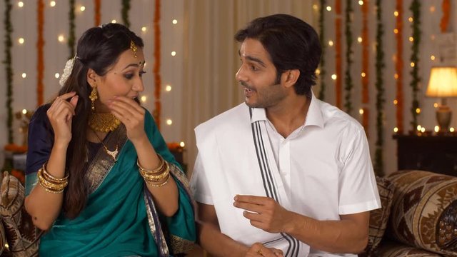 Newly married couple happily celebrating their first Diwali - festival of lights. Gift and Hugs. South Indian husband got a gold ring for his wife as a Diwali present  slipped the ring onto her bea...