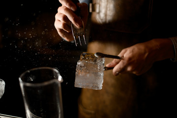 Close-up of bartender crushing an ice cube