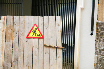 Road works sign on the wooden background. Man with a mohawk. Funny graffiti in the city.