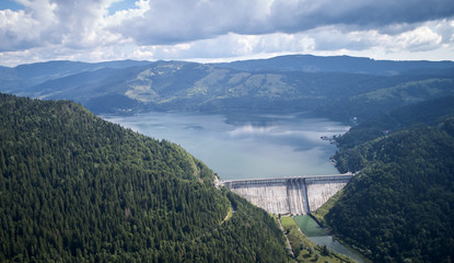 Fototapeta na wymiar hydroelectric station surrounded by forest and mountains