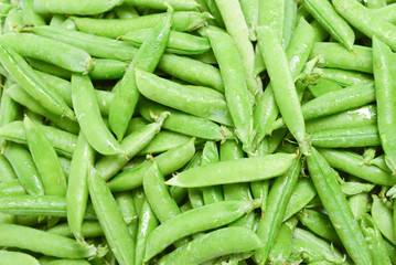 Fresh pea pods as background. Top view.