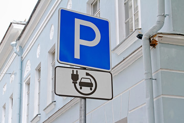 Road sign "Parking only for electric vehicles" on the background of the building