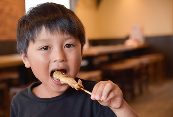 焼き鳥を食べる子供