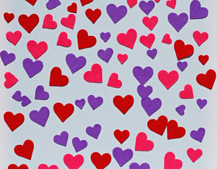 Red, pink and purple felt hearts on blue background