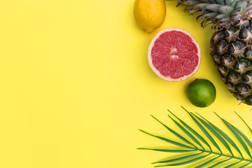 Tropical fruit with plant leaves pineapple grapefruit minimal food summer plant leaves bright yellow color background