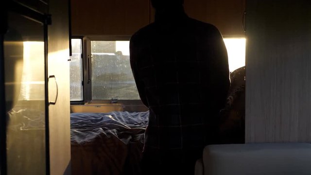 Man getting ready to go to sleep in travel trailer camping