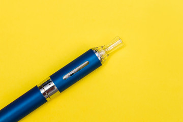Vape pen metal electronic cigarette with vaping yellow background