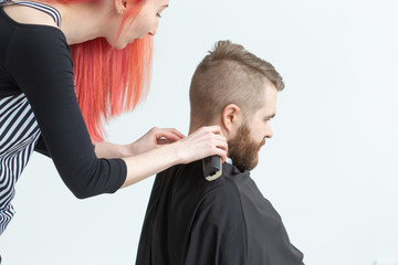 Hairdresser, stylist and barber shop concept - young woman hairstylist is going to cut a man