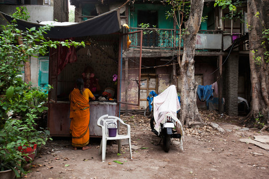 Woman praying to lord Ganesha near old building in Wadas of Pune, India