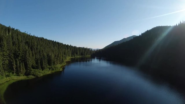 Peaceful Calm Water on Remote Alpine Lake Floating Down Aerial