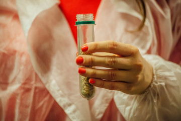 Female brewery worker hands holding malt samples in test tubes
