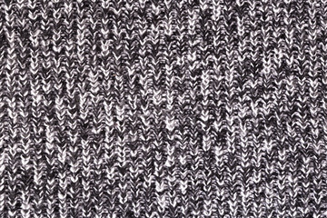 Background from a fabric texture. Wool knitted fabric with cable seamless pattern of white black color. Textile closeup.Concept of example, learning of knitting,concept of cover,notebooks, decorative 