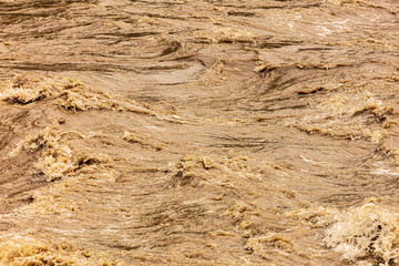 Dirty water runs in a mountain river