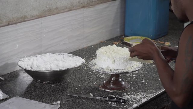 WOrking Of Icing Topping On Cake By A Cake Maker