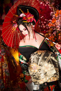 Geisha morena con paraguas y abanico