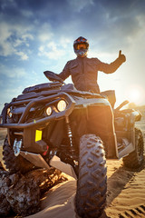 Racing powerful quad bike on the difficult sand in the summer. © Bondariev Volodymyr.