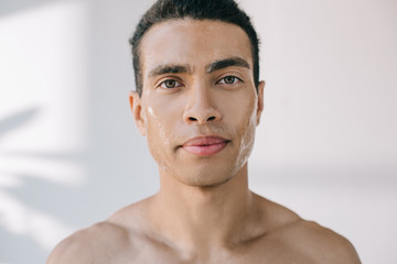 handsome serious young man with wet face looking at camera - obrazy, fototapety, plakaty
