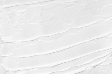 Texture of white face cream smeared on a white background. Cosmetic texture, face and body care.
