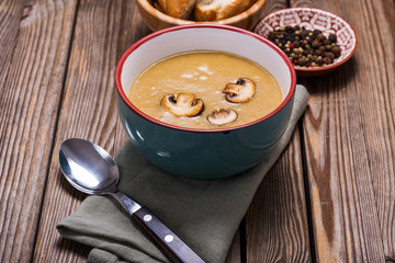 Champignon cream soup over rustic wooden background, delicious vegetable soup, healthy vegetarian and vegan food