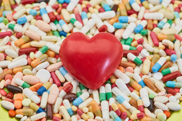 Fototapeta na wymiar Heart on heap of medicines as love concept