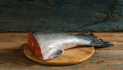 fresh salmon tail on a cutting wood kitchen