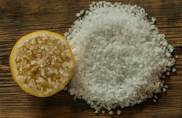 Heap of edible sea salt with large crystals on a brown wooden background