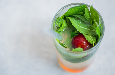 colorful fresh coctail with mint leafs and cherry plum inside glass