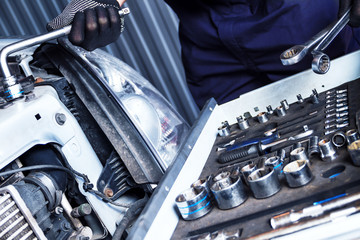 Closeup metal work tool of car mechanic at workshop auto repair shop. Repairman is choosing wrench for fixing vehicle. Repairer is repairing automobile at modern service station garage.