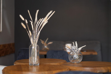 dried flowers in a vase on the background of the interior of the cafe