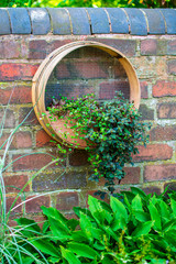 Traditional wooden garden riddle, garden sieve, which has been adapted for hanging plants in the garden