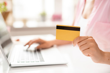 Plastic card in hand of young contemporary client of online shop