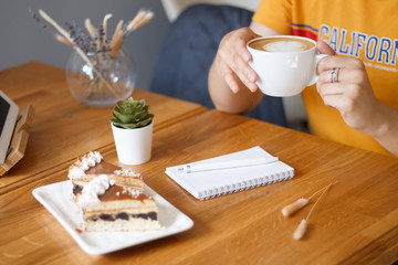  woman drinks coffee with cake.
