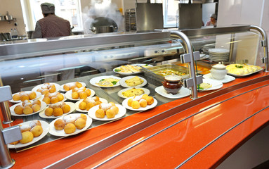 Plates and trays with dishes placed on a canteen counter