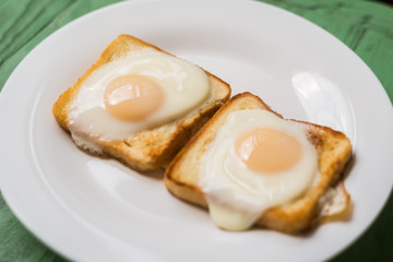 Toast with fried egg on a white plate. Sandwich with chicken egg. Snack, breakfast.