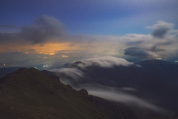 Naklejka na ściany i meble Clouds and mist on a moonlighted night on Agrafa Mountains