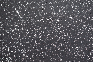 White paint small grainy splashes on black metal surface. Grunge noisy texture for graphic design.