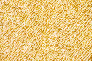 Soft yellow fluffy towel macro fabric texture.