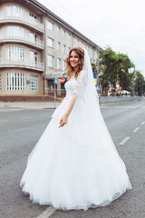 Fototapeta premium portrait of the bride in the city, young beautiful wedding bride